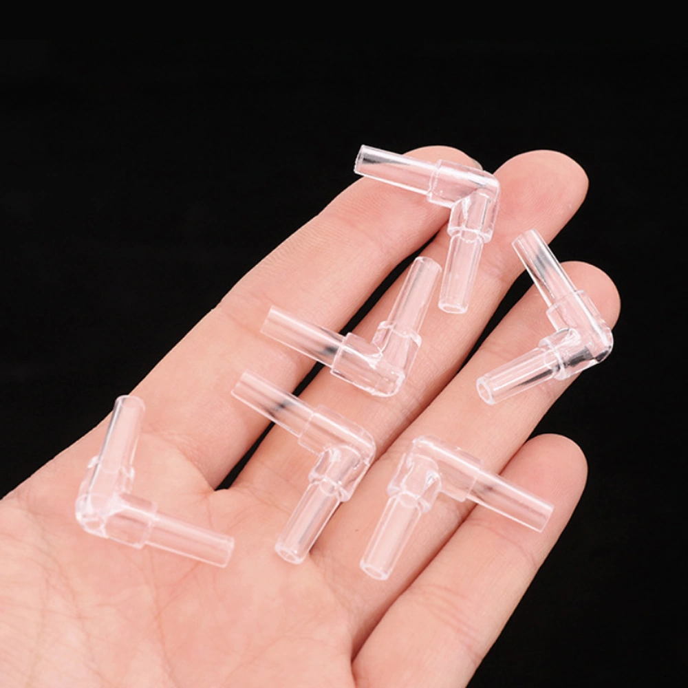 Six clear 90° aquarium airline elbow connectors resting on a hand for scale.