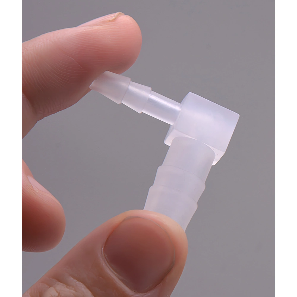 Translucent PP reducing barbed elbow connector held between fingertips, showing the different-size hose ends and 90° bend.